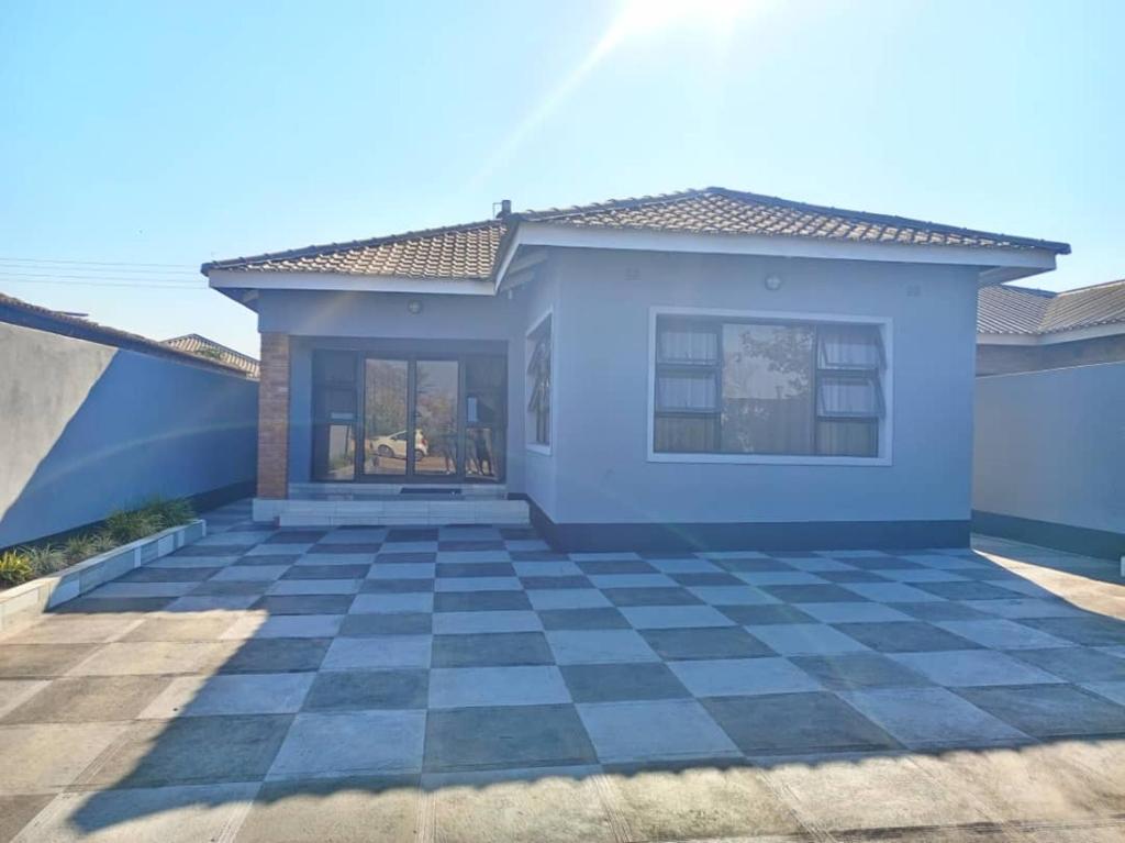 uma casa azul com piso xadrez em Tourice Lodge em Victoria Falls