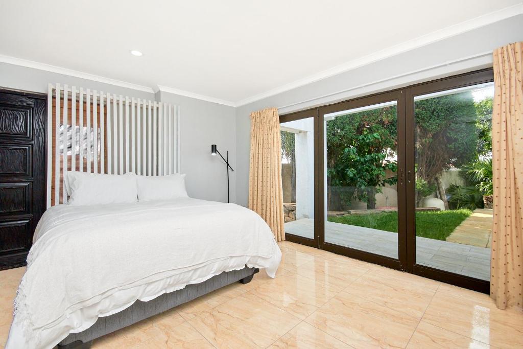 a bedroom with a bed and a large window at Private, Cosy and Stylish Stay at Nest24 Evans Park in Johannesburg