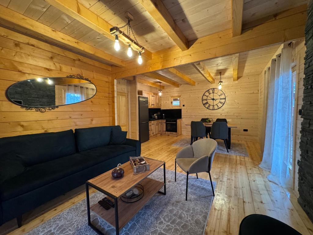 a living room with a couch and a table at Brvnara La Forêt in Žabljak