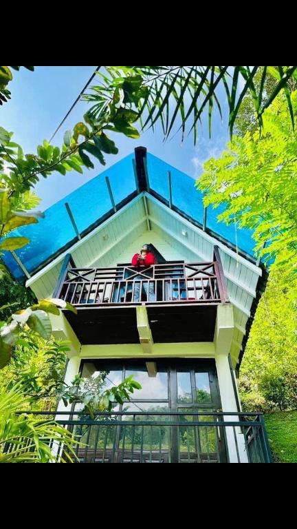 a building with a balcony with a person on it at Great villa lake resort in Karagoda