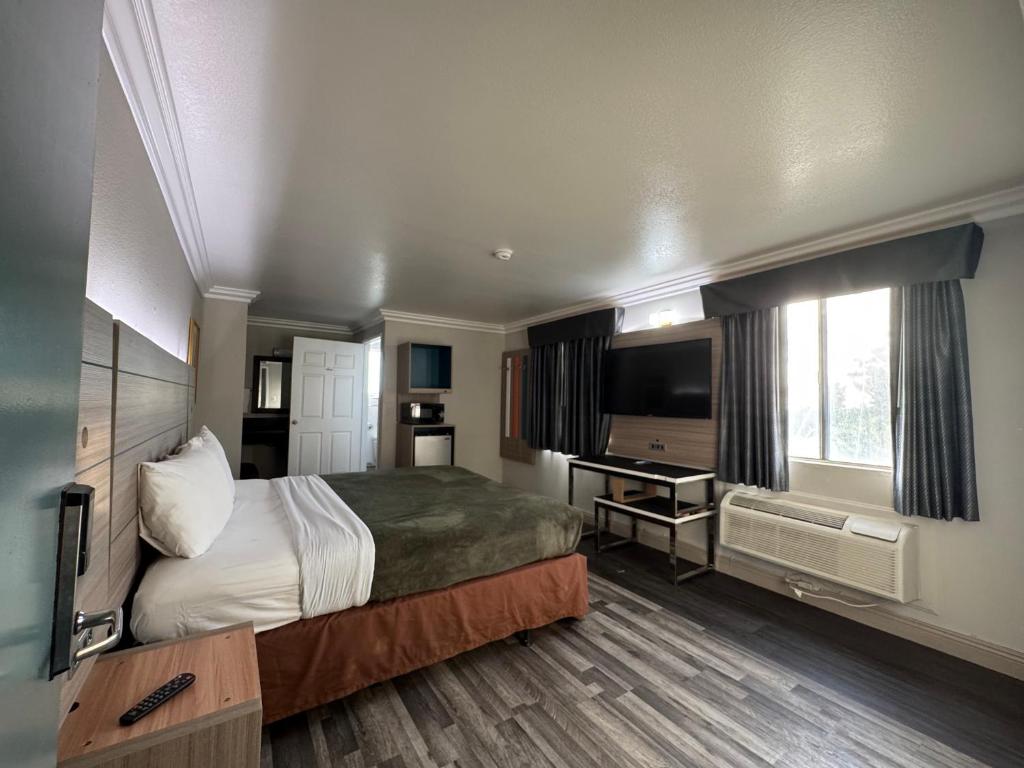 um quarto de hotel com uma cama e uma televisão em Rodeway Inn em Ventura