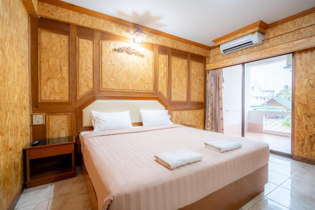 a bedroom with a bed with two towels on it at Chatsuree Mansion in Ubon Ratchathani