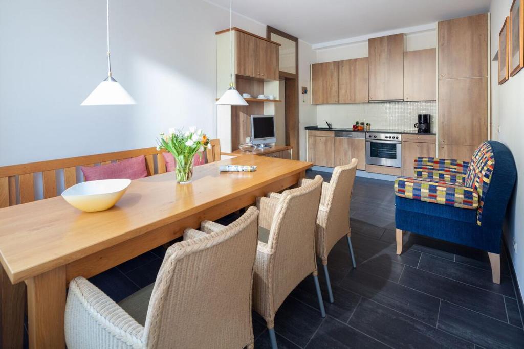 eine Küche und ein Esszimmer mit einem Holztisch und Stühlen in der Unterkunft Ferienwohnung Strandhafer Norderney in Norderney