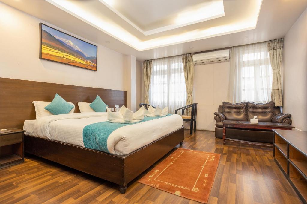 una habitación de hotel con una cama y una silla en Greatwall International Hotel, en Katmandú