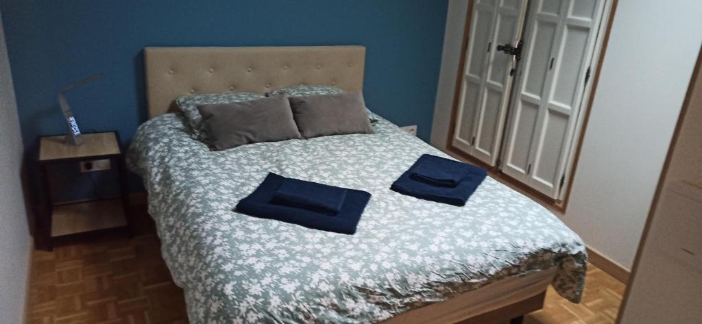 a bed with two blue pillows on top of it at Studio GIVRY in Givry