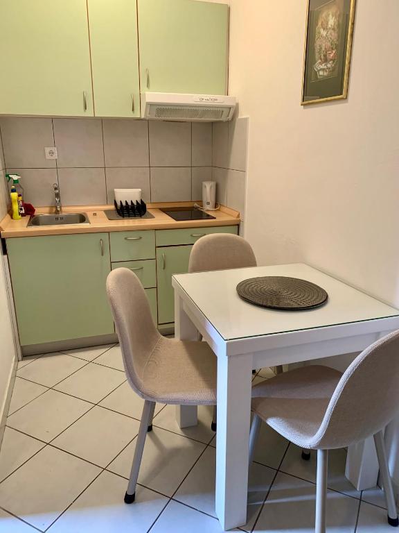 a kitchen with a table and chairs and a sink at Apartments Lepur in Vodice