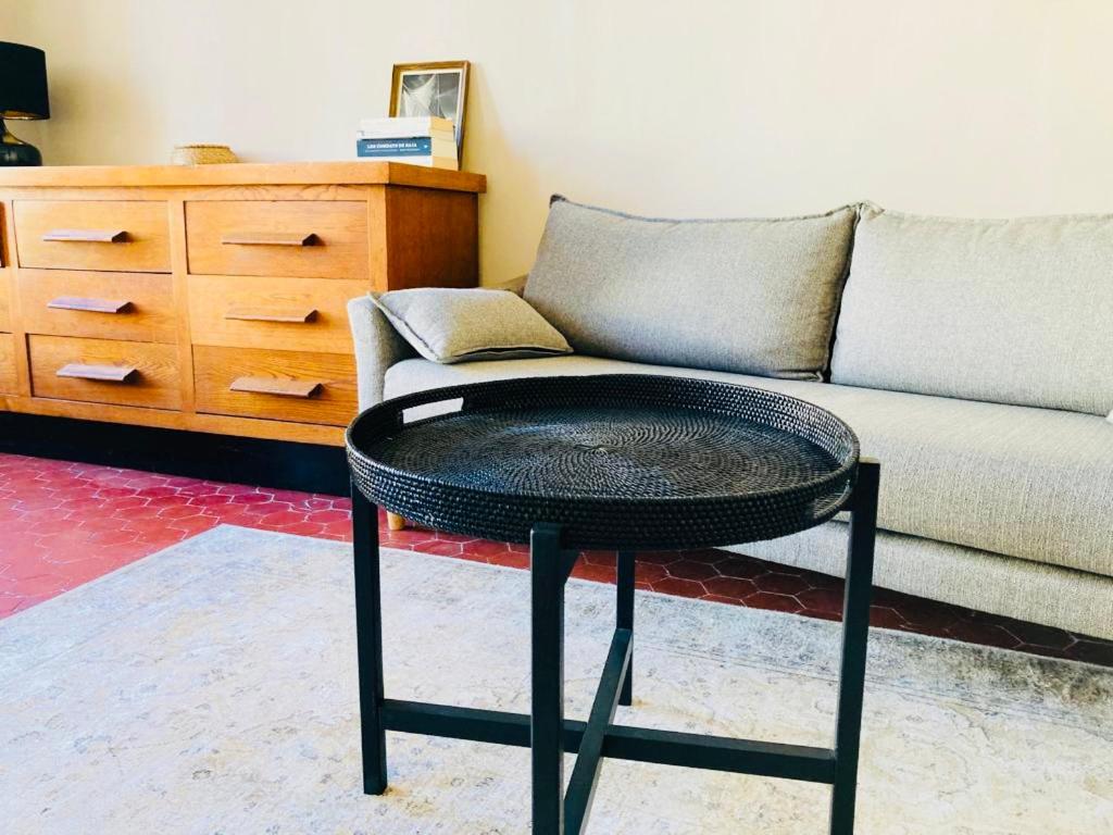 - une table noire dans le salon avec un canapé dans l'établissement Appartement lumineux Joliette Panier Vieux-Port, à Marseille