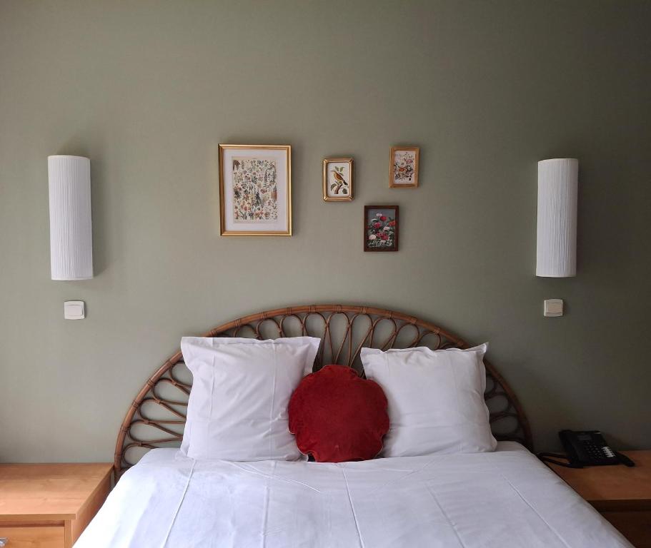 - un lit avec un oreiller rouge dans l'établissement Hostellerie Du Lys, à Lamorlaye
