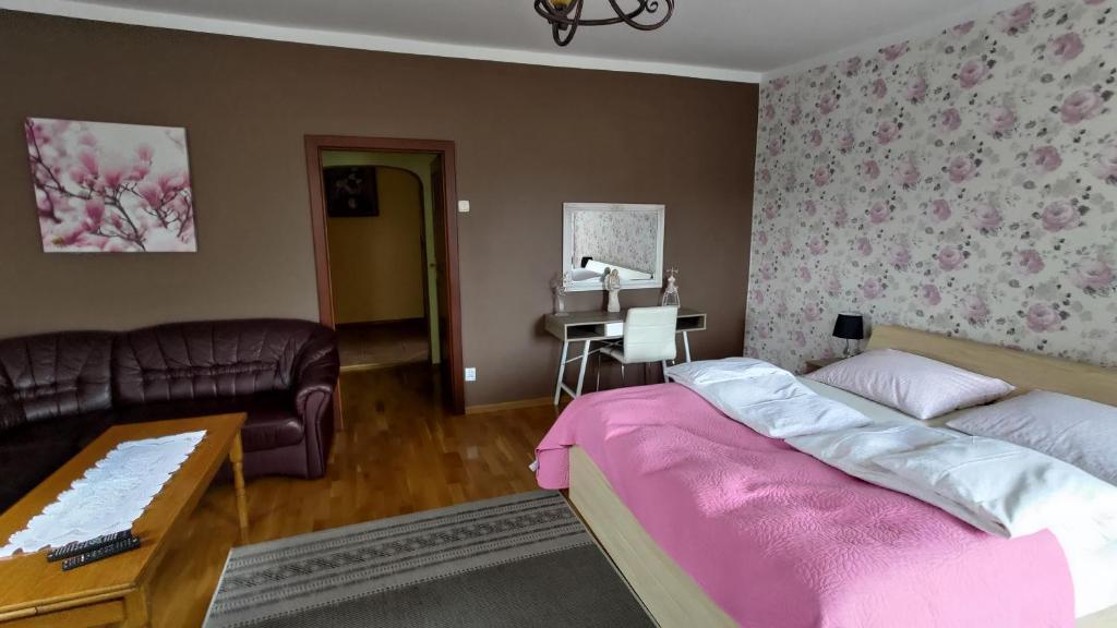 een slaapkamer met een bed, een bank en een tafel bij Fajne Miejsce in Wambierzyce