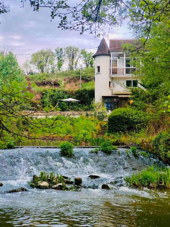 une maison sur une colline à côté d'une rivière dans l'établissement Au bord de l'eau, à Tendu