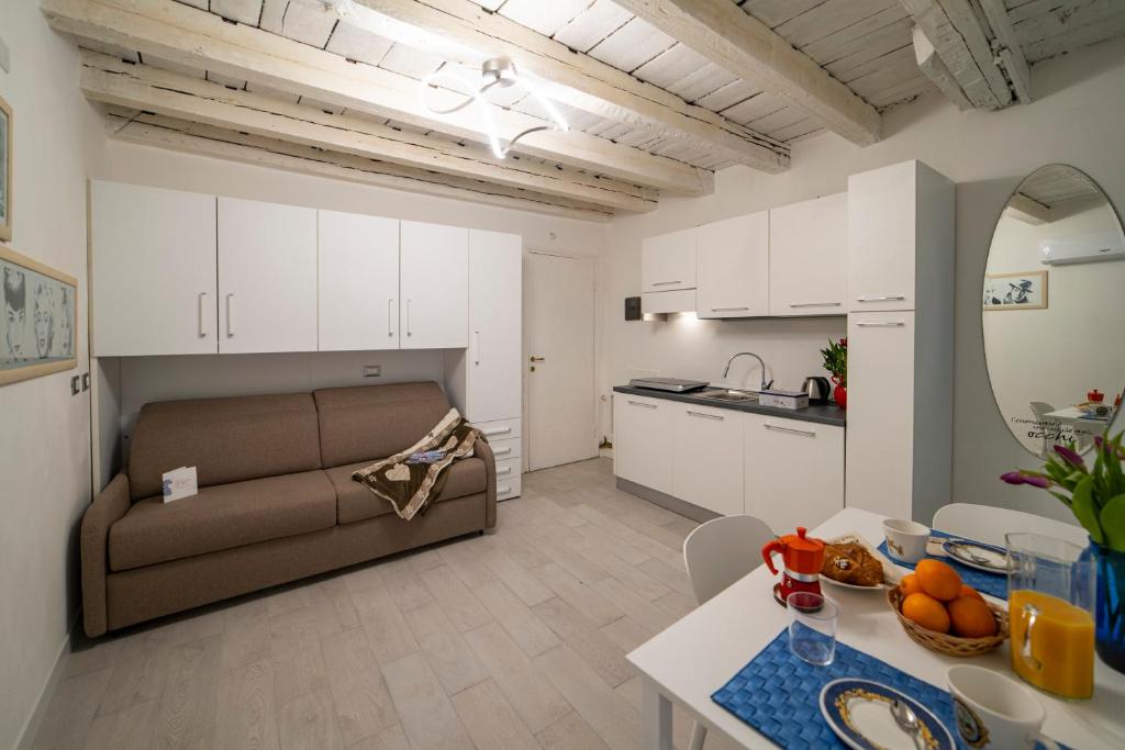 a living room and kitchen with a couch and a table at MagentA NesT - Loft&Charme in Brescia