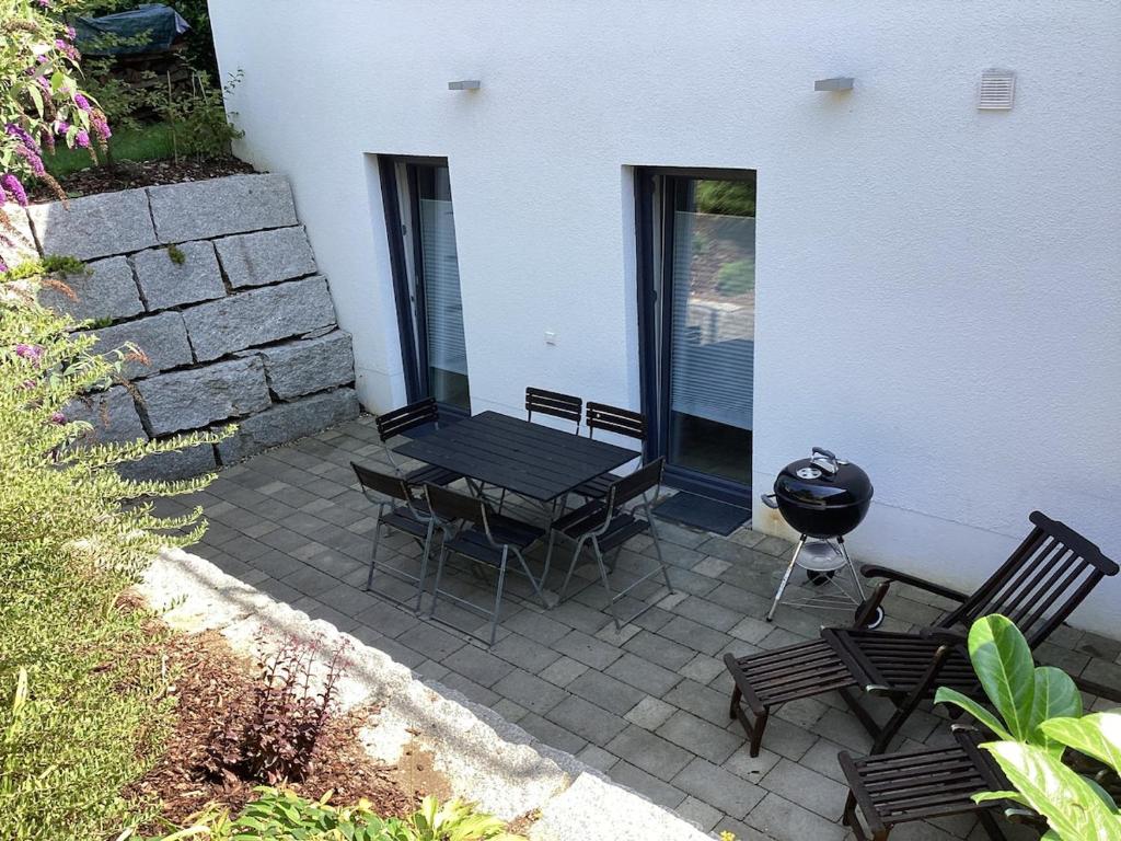 a patio with a grill and a table and chairs at Schöne FeWo im Illertal in Oberopfingen