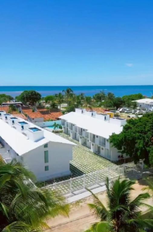an aerial view of a white building and the ocean at Mar Calmo, 150m da praia in Santa Cruz Cabrália