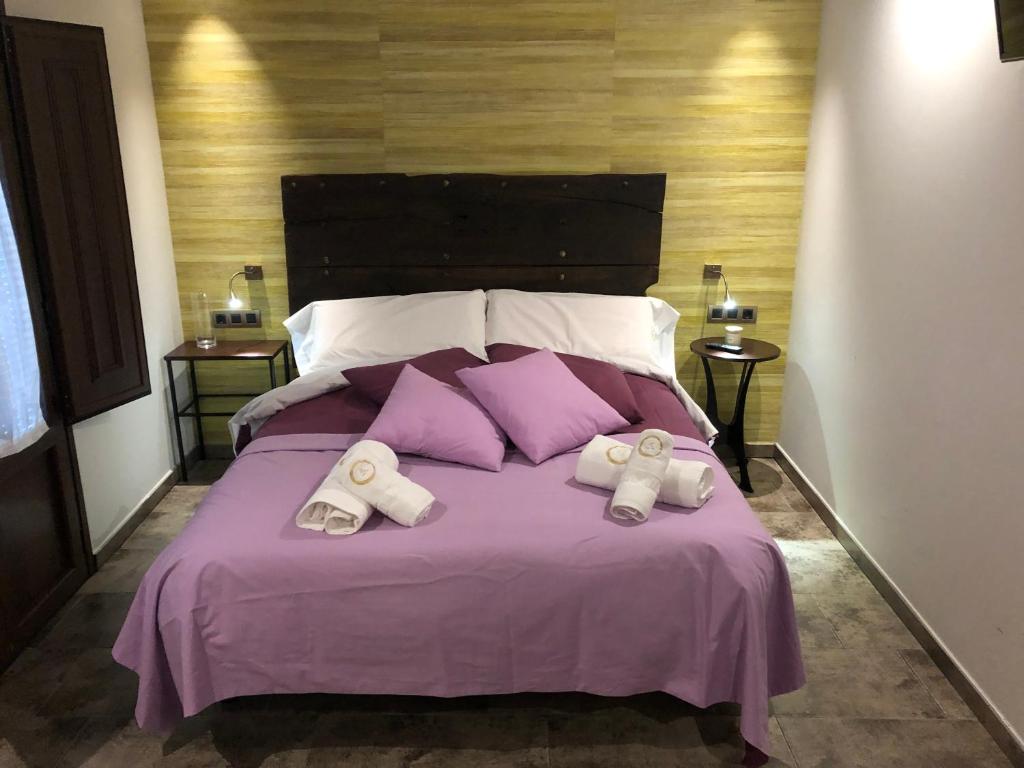 a bedroom with a purple bed with purple pillows at Casa FOR HABITACIONES in Labuerda