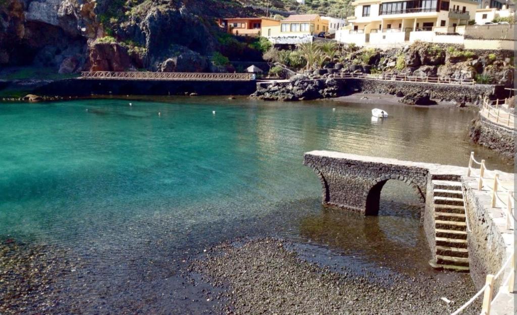 a bench sitting on the shore of a body of water at Eserò in Tamaduste