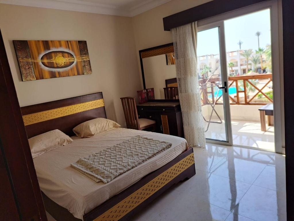 a bedroom with a bed and a desk and a balcony at jo sunny lakes in Sharm El Sheikh