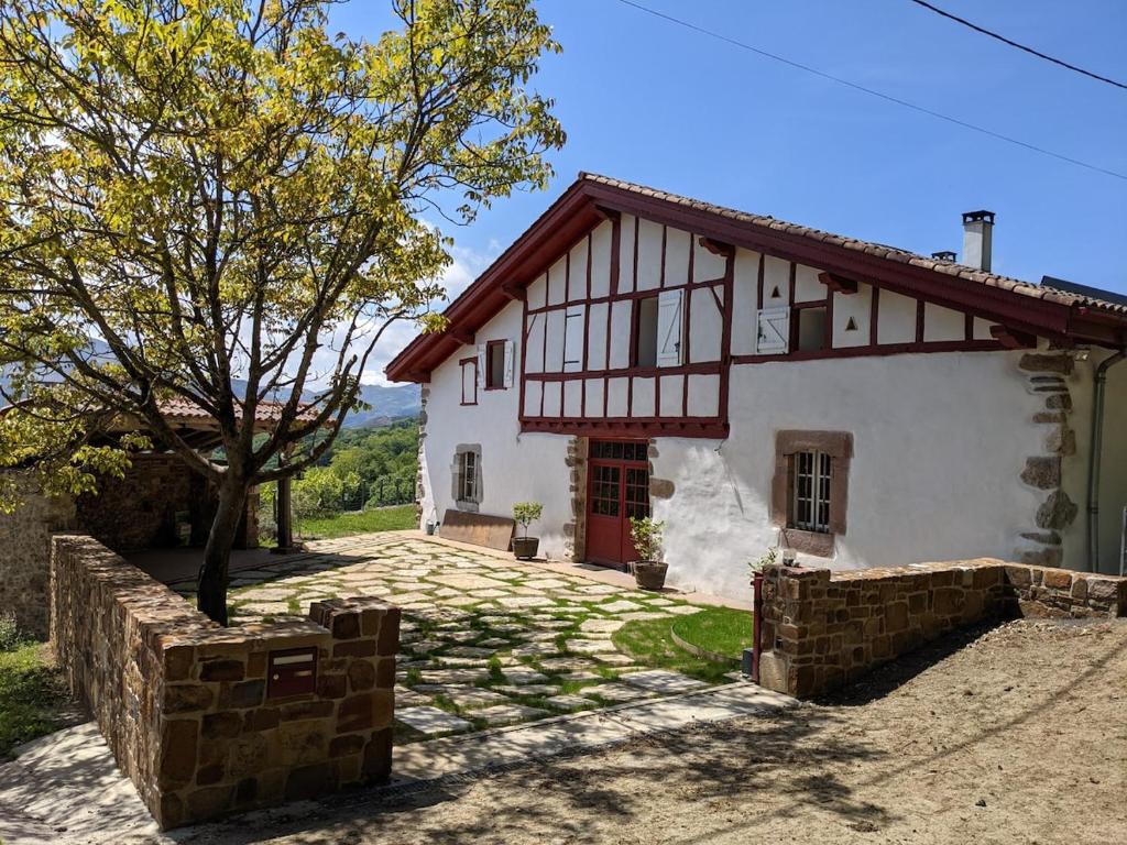 une maison blanche avec un arbre devant dans l'établissement Grande Ferme Basque proche Montagnes et Plages, à Macaye