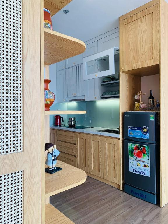 a kitchen with a black refrigerator in a kitchen at SP Sky OASIS 27 06 QuynhDao HomeStay in Kim Quan