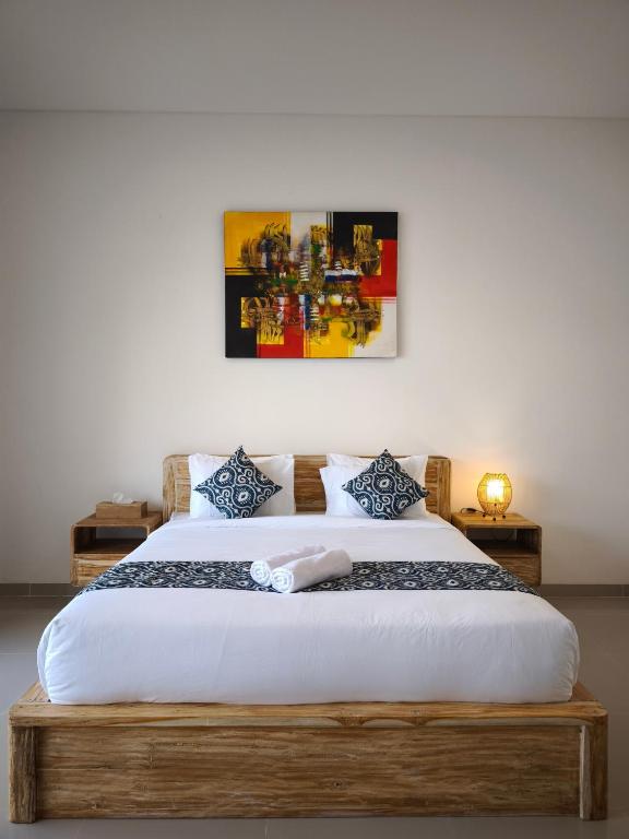 a bedroom with a large bed with a wooden frame at Kubu Shankara Homestay in Uluwatu