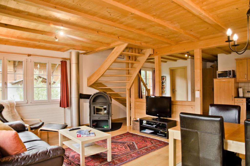 a living room with a staircase in a house at Delightful 4star Chalet Kiwi Apt in Grindelwald