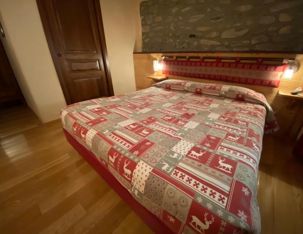 una camera da letto con un letto con una trapunta natalizia sopra di Chambres D'hôtes Maribel a Pré-Saint-Didier