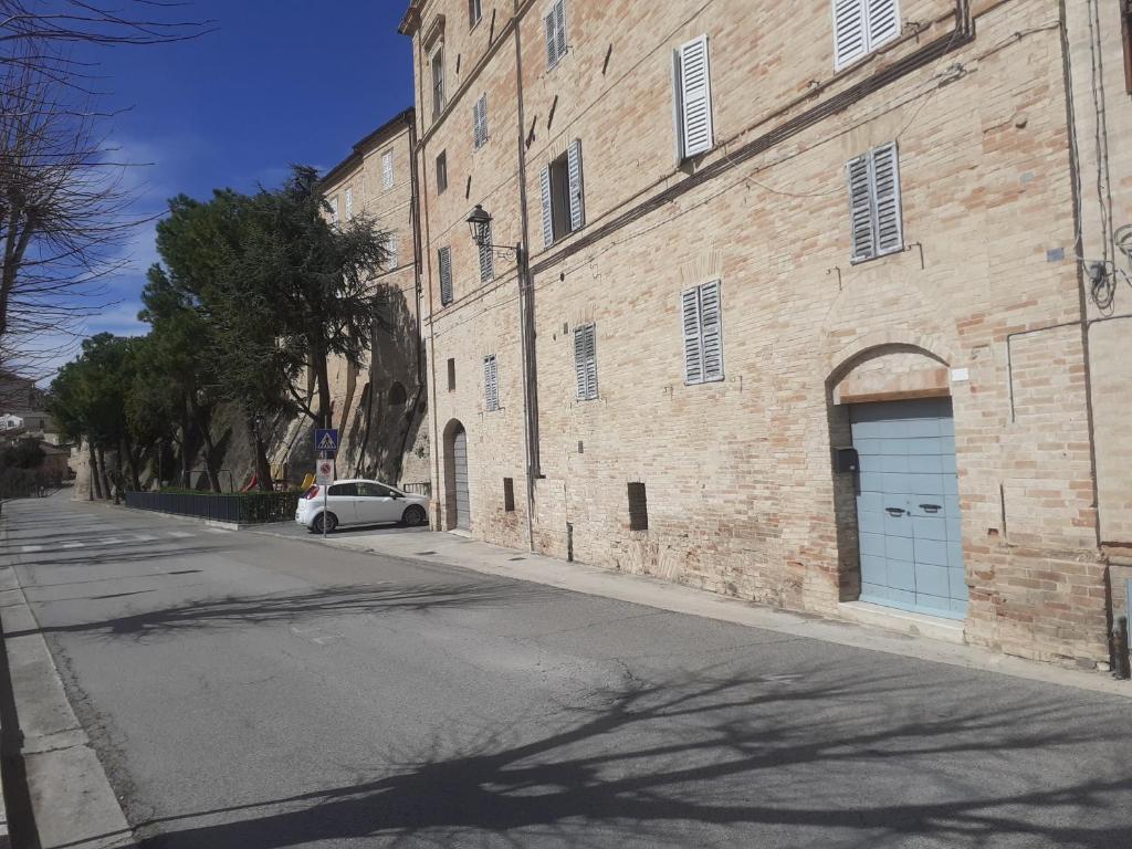 a car parked next to a brick building with a blue garage at casa viale marconi in Monte San Pietrangeli