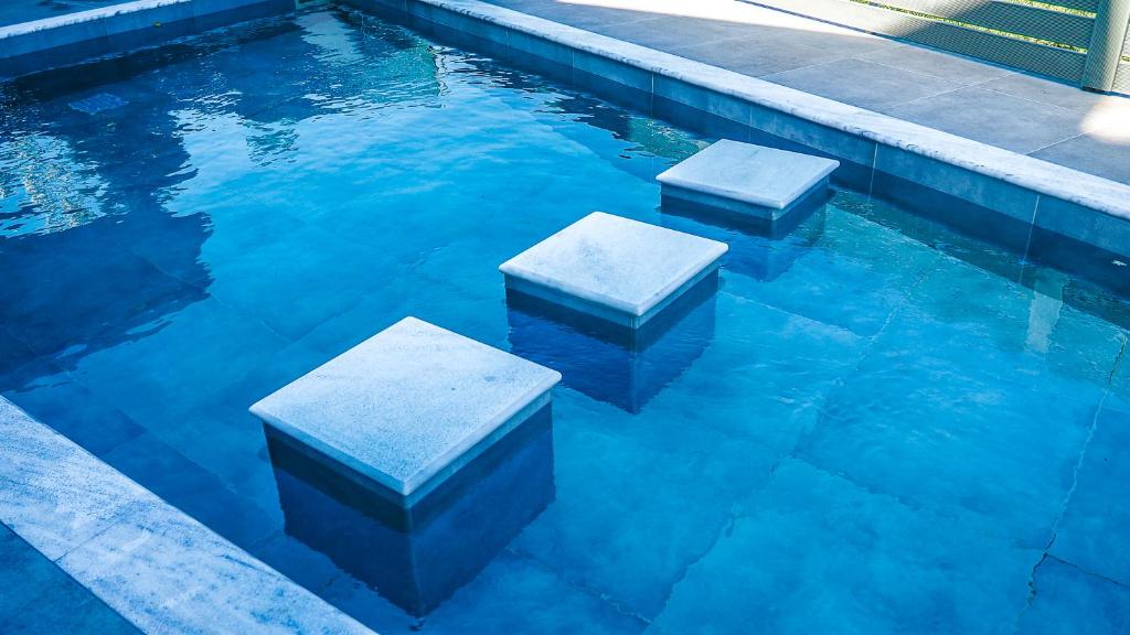 a pool with two stepping benches in the water at Olive Scent in Gouves