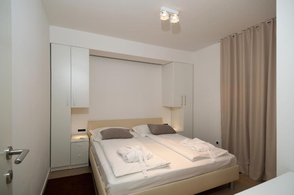 a bedroom with a white bed with white towels on it at Villa Paulina in Brela