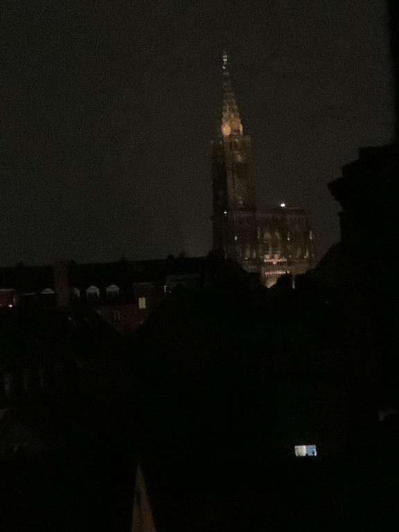 une vue d'une tour de l'horloge la nuit dans l'établissement La Cigogne, à Strasbourg