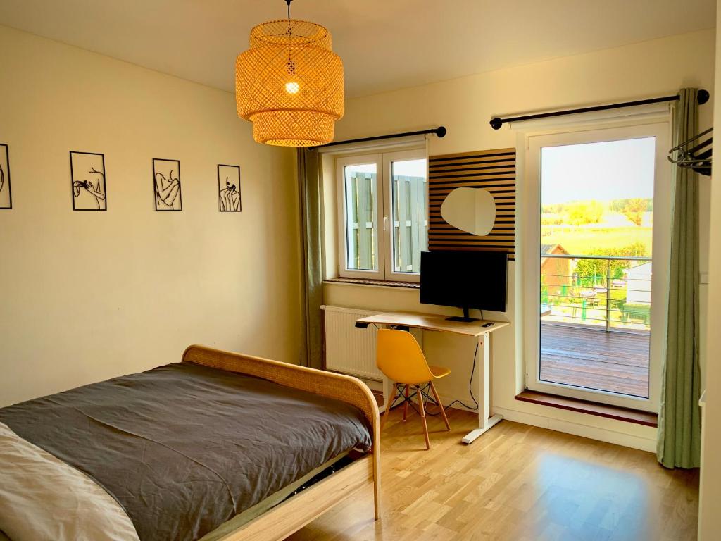 a bedroom with a bed and a desk and a window at Wohlfühl Oase mit Sauna vor den Toren Berlins in Nauen