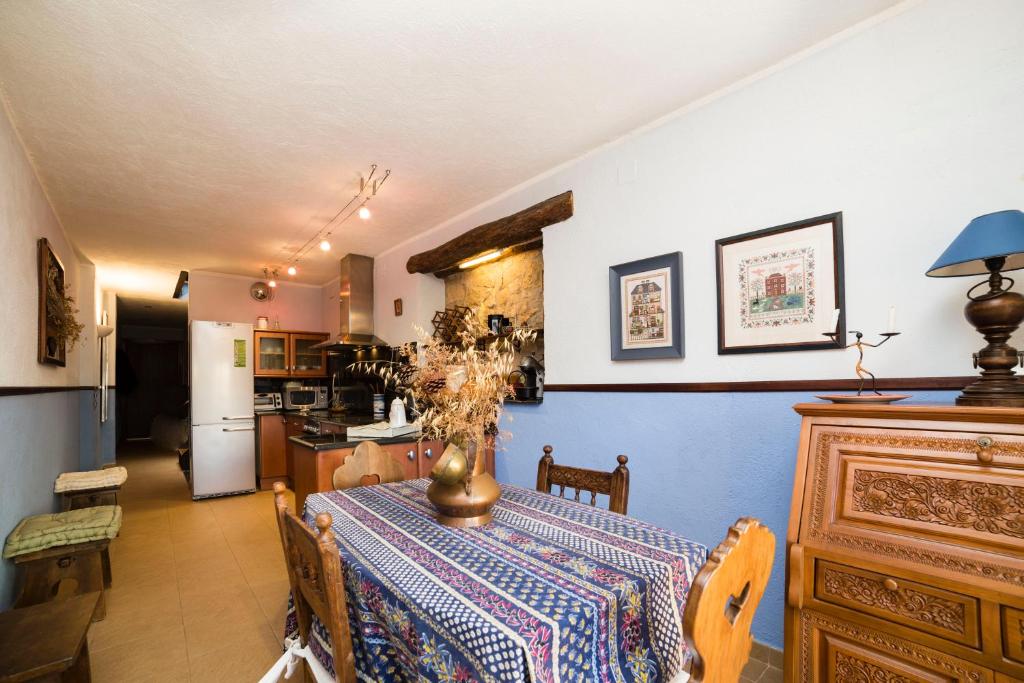 a dining room with a table and a kitchen at Rural Colldejou Cal Caterí in Colldejou
