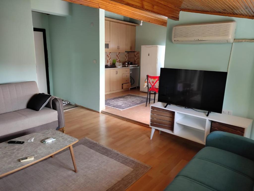 a living room with a couch and a flat screen tv at Garden Prizma Apart in Kemer