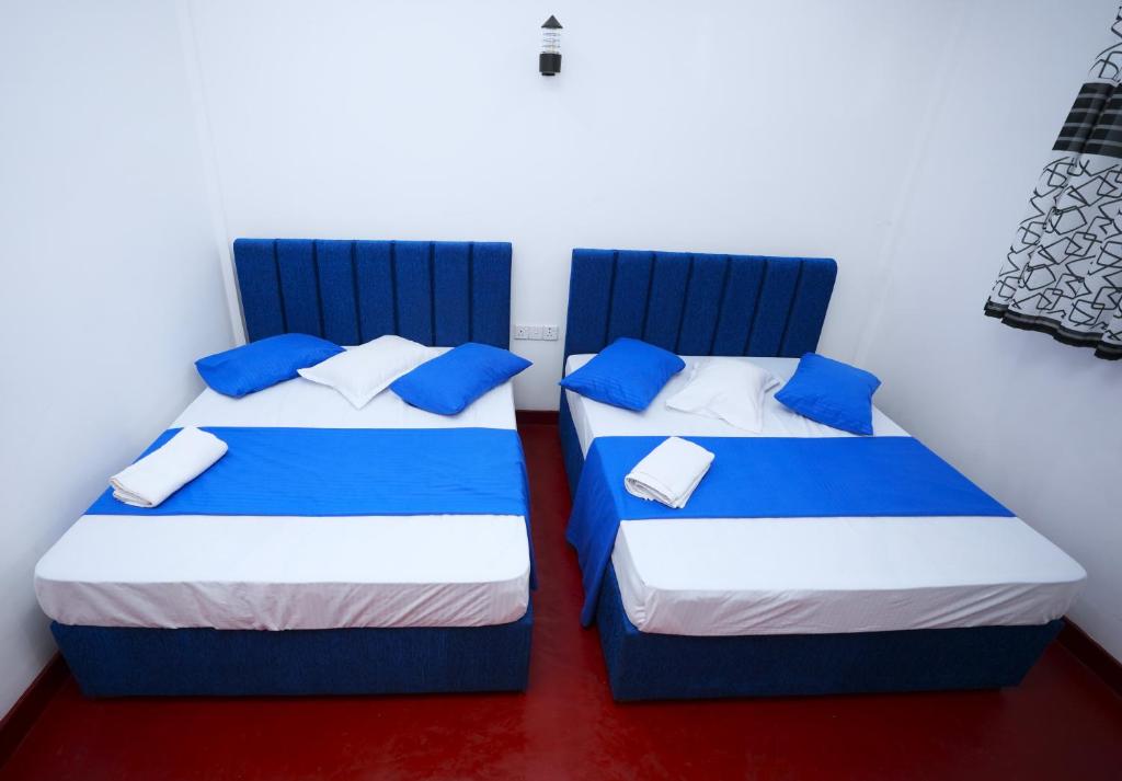 ジャフナにあるKCS HOLIDAY INN Pvt Ltdの部屋に並んで置かれた2つのベッド