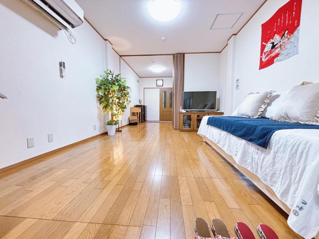 a bedroom with a bed and a flat screen tv at 桜の宿-大阪城Osaka castle-105m2 private-5Way access-KIX USJ 難波心斎橋 Direct in Osaka
