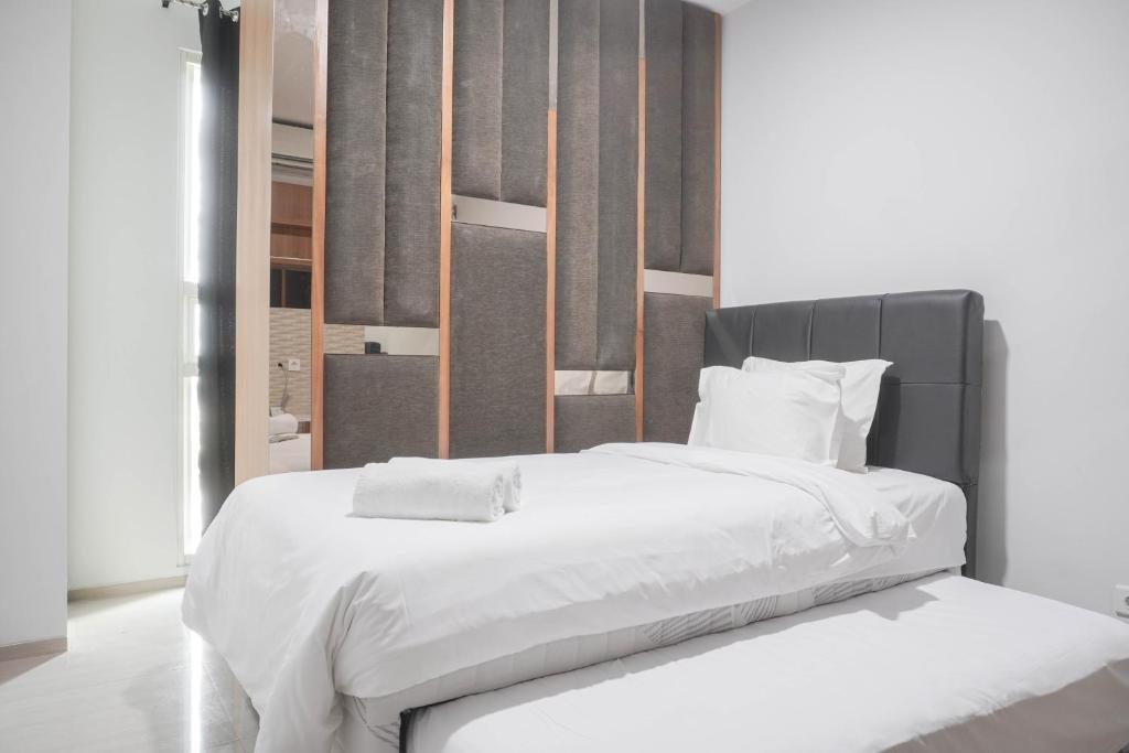 Ένα ή περισσότερα κρεβάτια σε δωμάτιο στο Nice and Comfort 1BR at Citralake Suites Apartment By Travelio