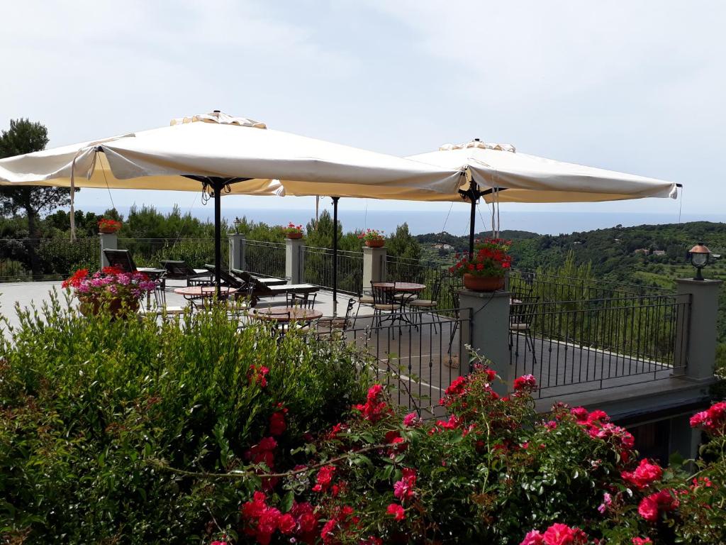 a patio with tables and umbrellas and flowers at Arpaderba B&B in Livorno