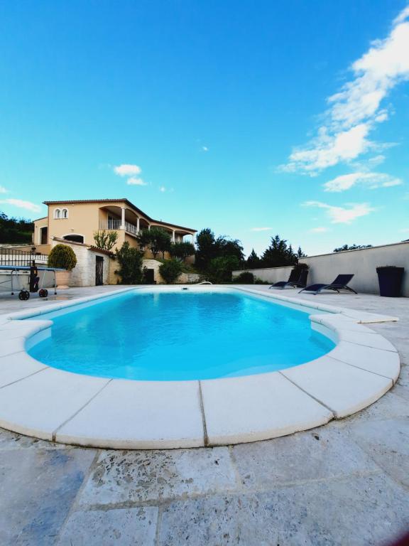 une grande piscine avec de l'eau bleue dans l'établissement Somptueuse villa avec piscine chauffée, à Rousson