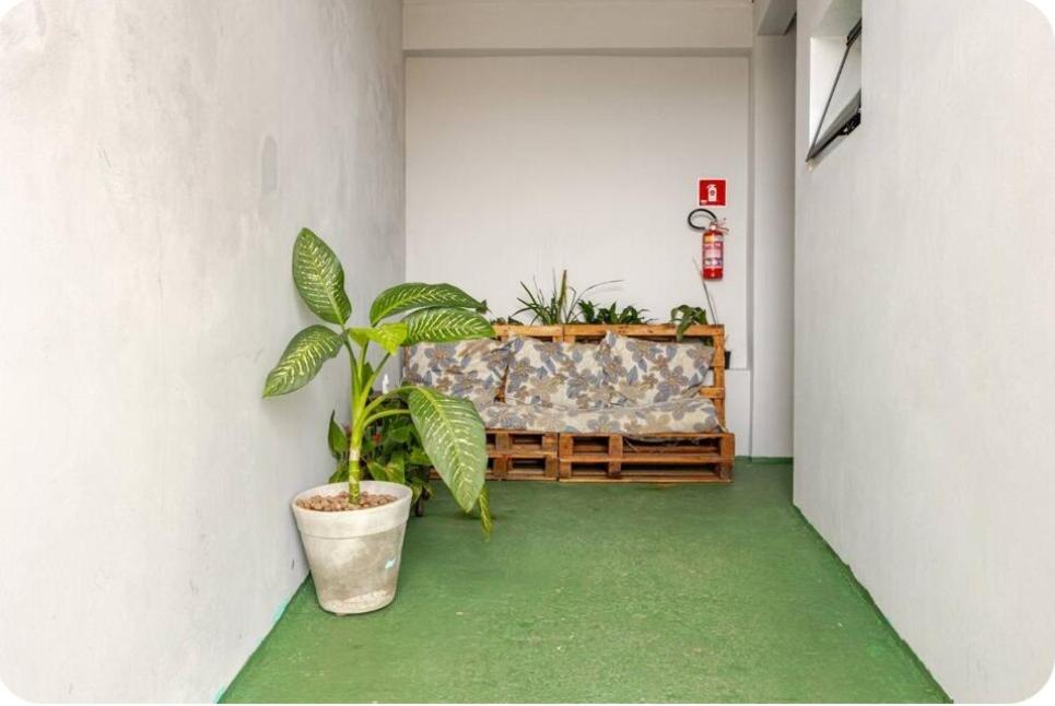 een kamer met een bank en een potplant bij Pousada da Vila Araçariguama-SP in Araçariguama