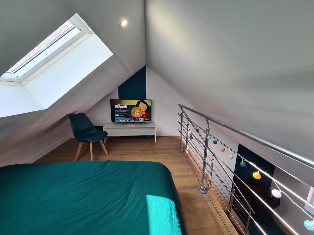 - une chambre mansardée avec un lit et une télévision dans l'établissement Le Sommet de l'Opale I Spacieux & Confort, à Boulogne-sur-Mer