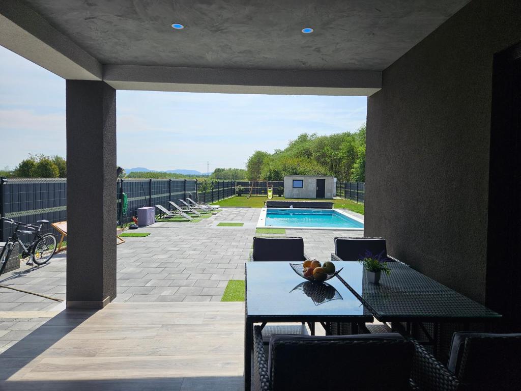 a patio with a table and chairs and a pool at Villa Joy with Pool,Jacuzzi,E Auto Station in Sračinec