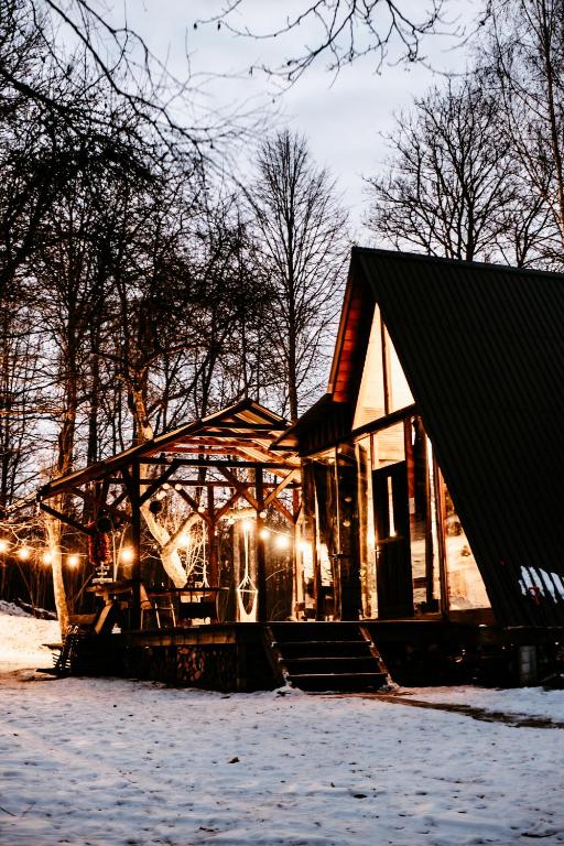 a small building with lights on it in the snow at Koka namiņš "Pasaka" in Vecumnieki