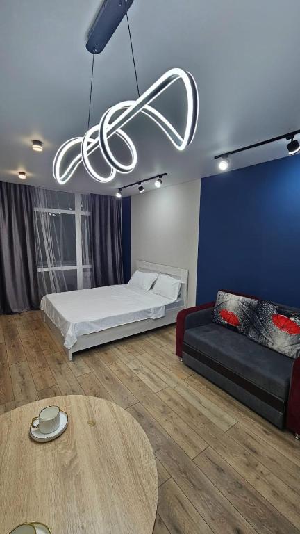 a room with a bed and a couch and a table at 1 комнатные апартаменты in Semey