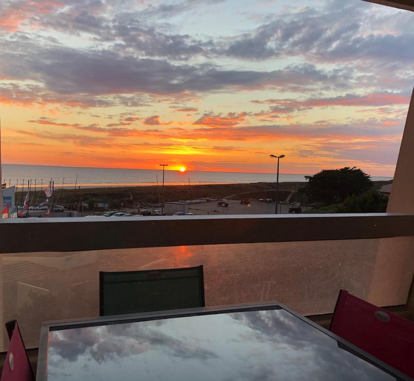 un ordinateur installé sur un balcon avec vue sur le coucher du soleil dans l'établissement Studio face Mer, à Saint-Jean-de-Monts