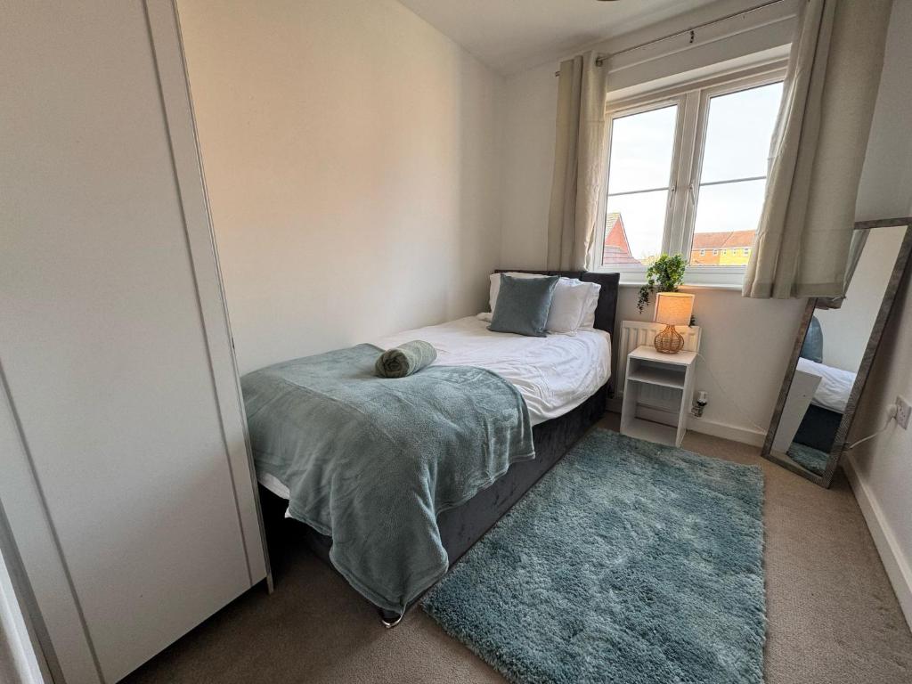a small bedroom with a bed and a window at Hanwell House SN25 Long Stays Sleep 5 Free Parking in Swindon