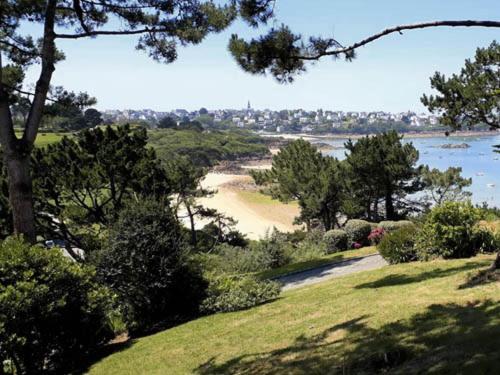 - une vue sur la plage avec des arbres et de l'eau dans l'établissement Ty Glaz, à Carantec