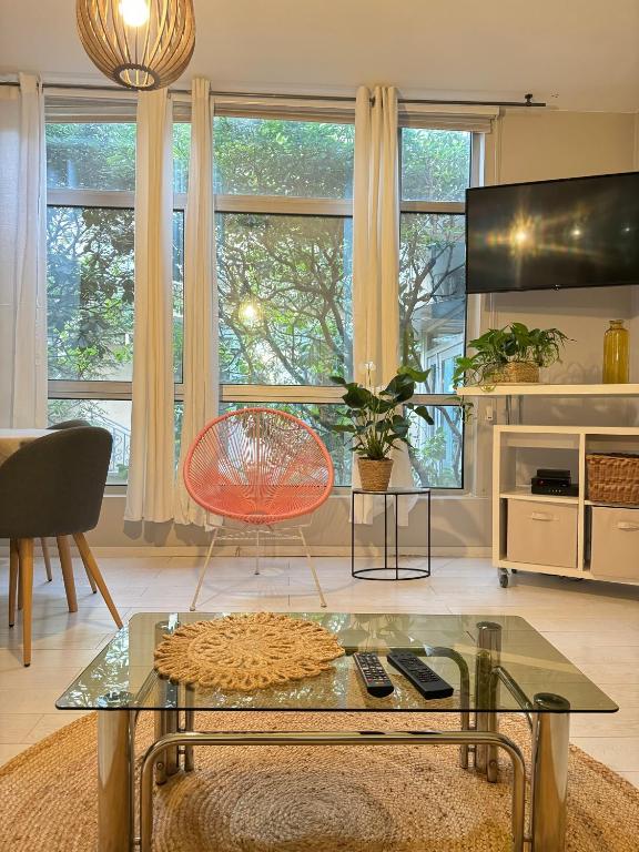 un salon avec une table en verre et un fauteuil rouge dans l'établissement Triplex cosy, à Lyon