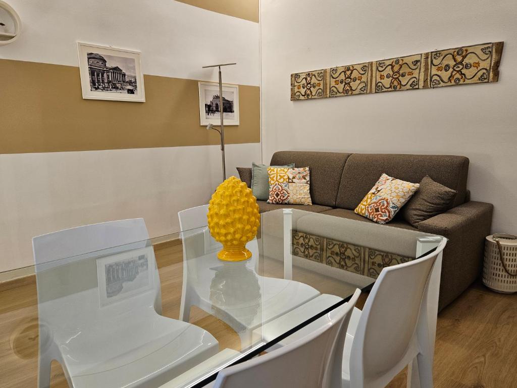 a living room with a glass table and a couch at Appartamento XII Gennaio 3 in Palermo