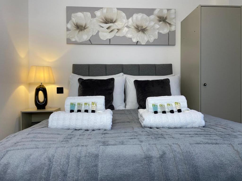 a bedroom with a large bed with two pillows at Town Centre Two-Bedroom in Swindon