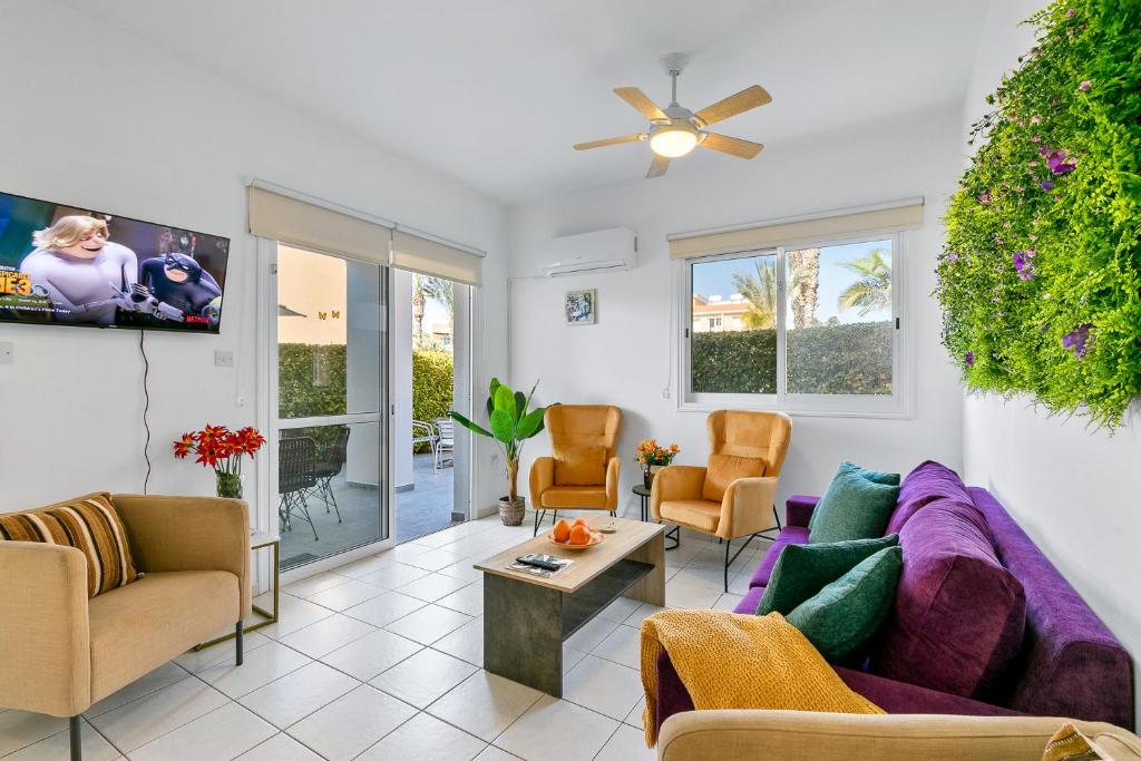 a living room with a purple couch and chairs at Iris Bloom Holiday Apartment in Paphos City