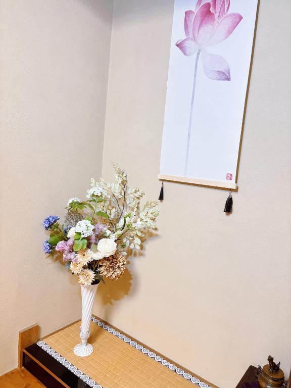 a vase filled with flowers sitting on a table at 桜の宿-大阪城Osaka castle-105m2 private-5Way access-KIX USJ 難波心斎橋 Direct in Osaka